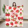 A pink strawberry print throw blanket featuring a cartoon strawberry shortcake character.