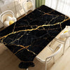 Black marble pattern table cloth with gold veining displayed on a wooden floor.