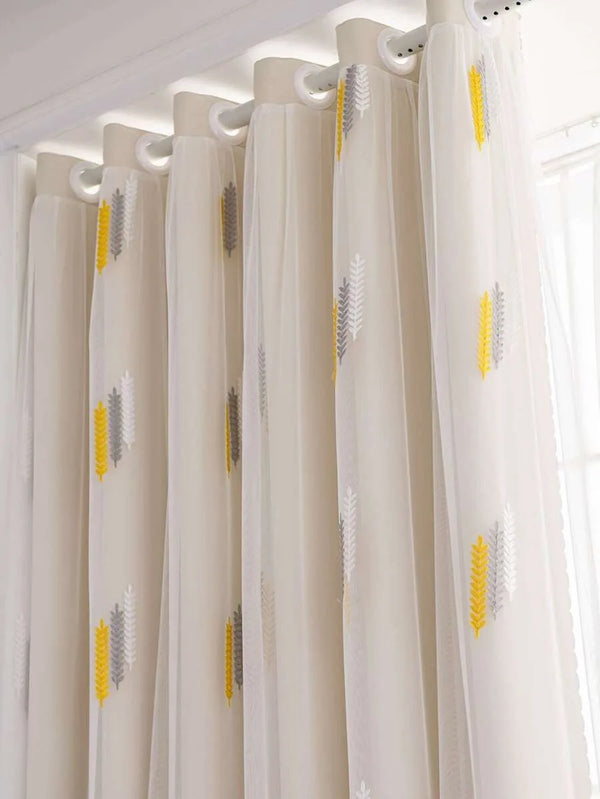 Elegant wheat field embroidered sheer white curtains hanging from a rod
