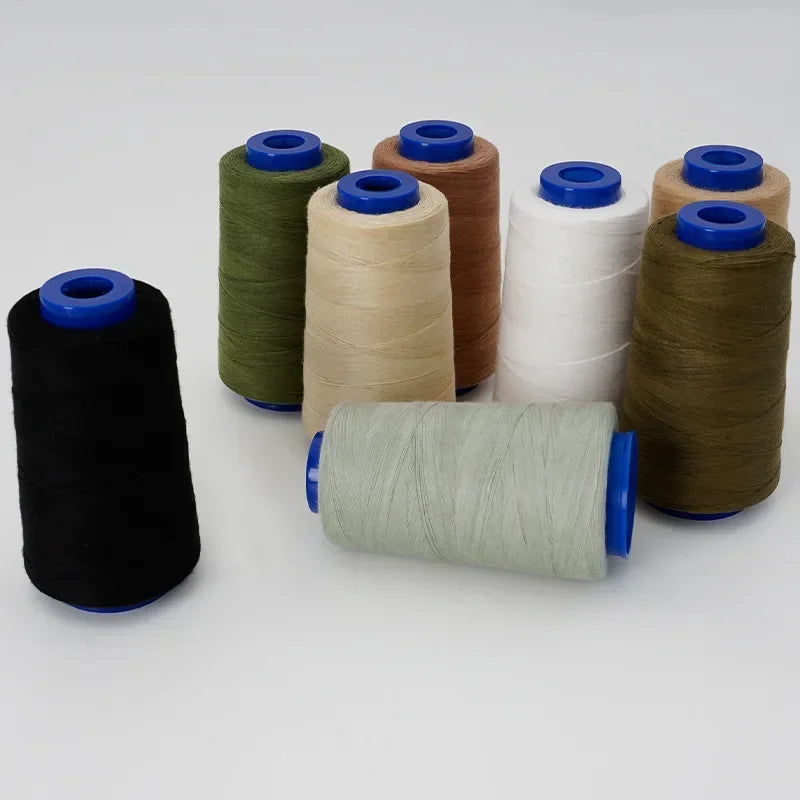 A collection of spools of heavy-duty waterproof sewing thread in various colors including green, beige, white, and brown.