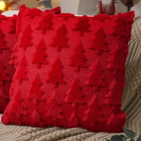 A bright red knitted cushion cover featuring a textured pattern of small Christmas trees.