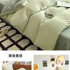 A set of light green ultra-soft washed cotton quilt bedding featuring a duvet and pillows on a bed.