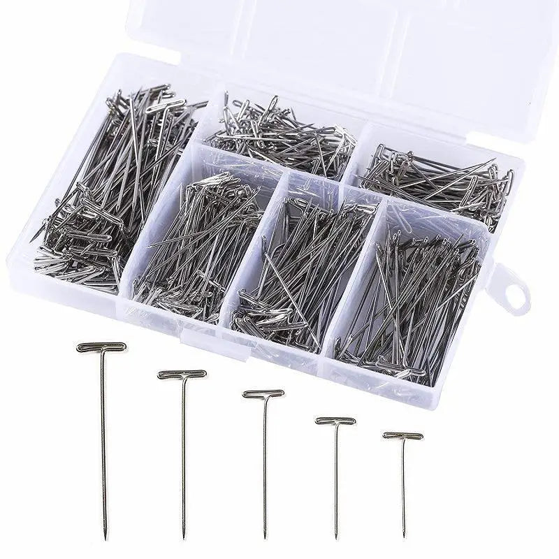 A clear plastic box containing numerous stainless steel T-pins for knitting blocking and sewing.