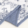 A close-up of a light blue floral summer duvet featuring detailed botanical illustrations on white fabric.