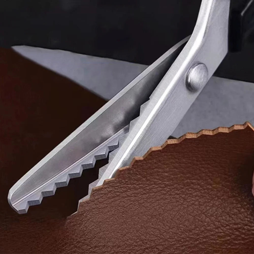 Silver professional pinking shears cutting into brown leather fabric