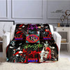 A black and red printed flannel travel blanket draped over a white sofa.