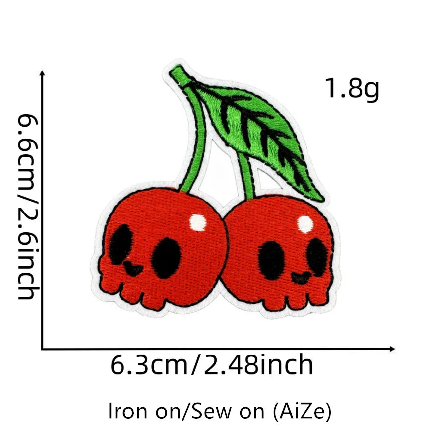 Two red cherry embroidered fruit patches on a white background.
