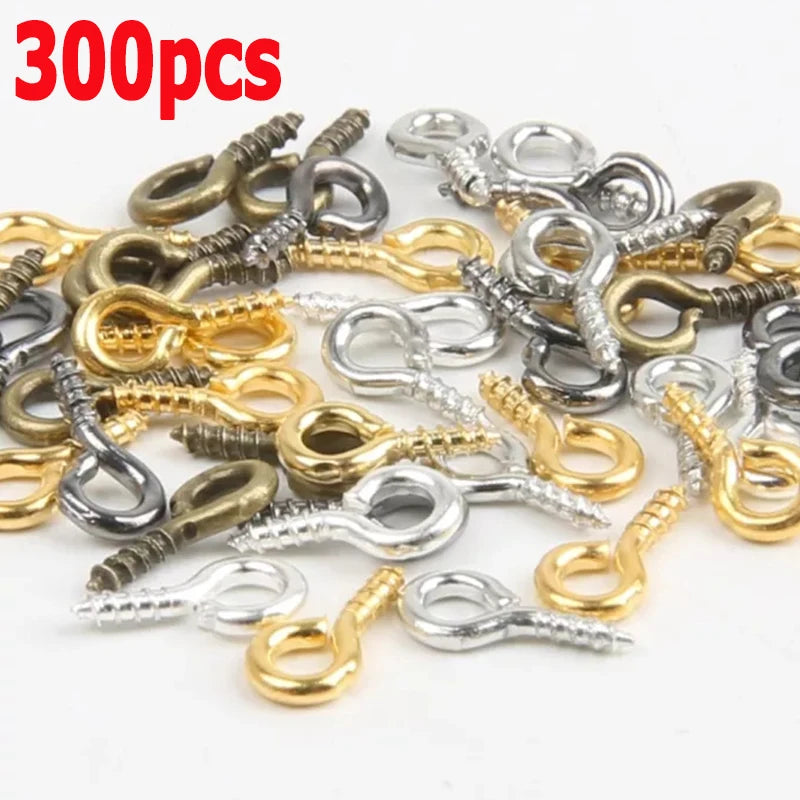 A pile of various silver and gold eye screw pins for jewelry making.