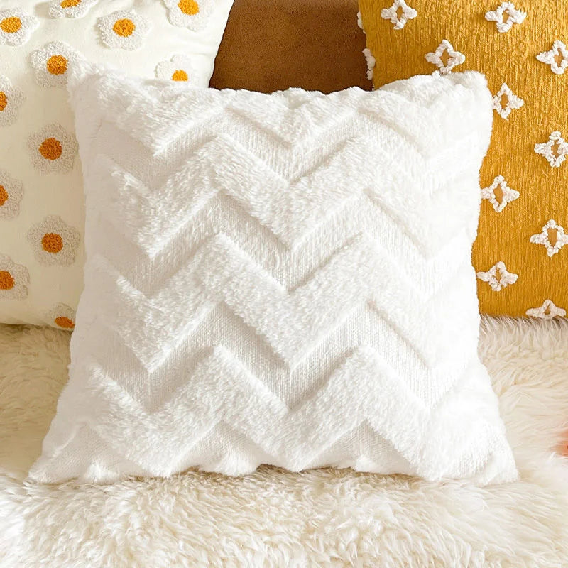 White chevron textured throw pillow resting on a fluffy white rug next to yellow and brown pillows.