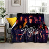 A dark purple fleece throw blanket featuring a collage of Stray Kids members in various poses.