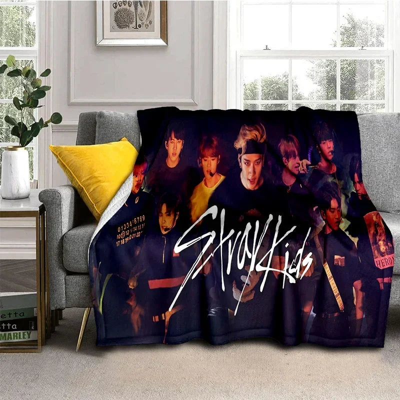 A dark purple fleece throw blanket featuring a collage of Stray Kids members in various poses.