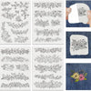 A collection of black line embroidery patterns printed on white fabric and displayed on denim fabric.