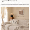 A light beige herringbone chenille sofa cover draped over a sofa in a bright living room setting.
