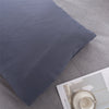 A dark gray microfiber pillow cover is shown on a light gray fabric background.