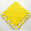 A yellow soft interlocking foam play mat shaped like a diamond, with several interlocking pieces laid out.