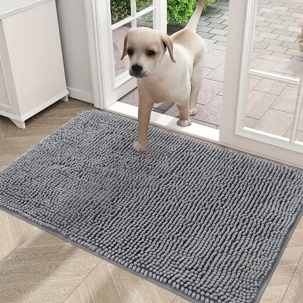 A fluffy gray pet door mat with a textured surface is placed on a light wood floor near a window.