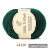 A ball of dark green wool thread with a label indicating the product details and weight per pack.