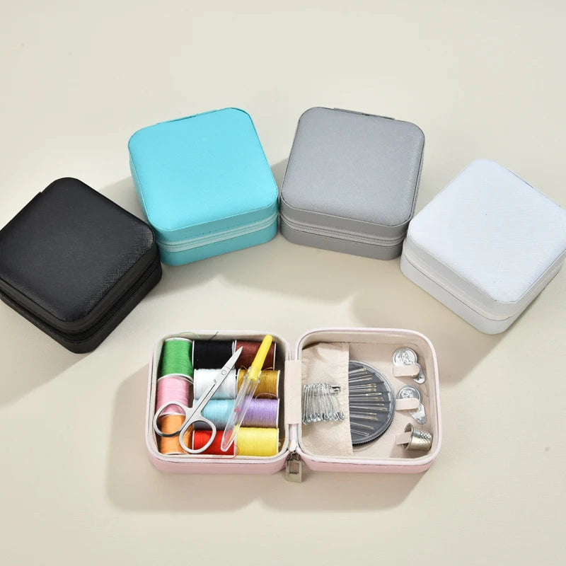 A collection of colorful and gray multifunction leather sewing boxes and a small pink box containing a hand sewing kit.