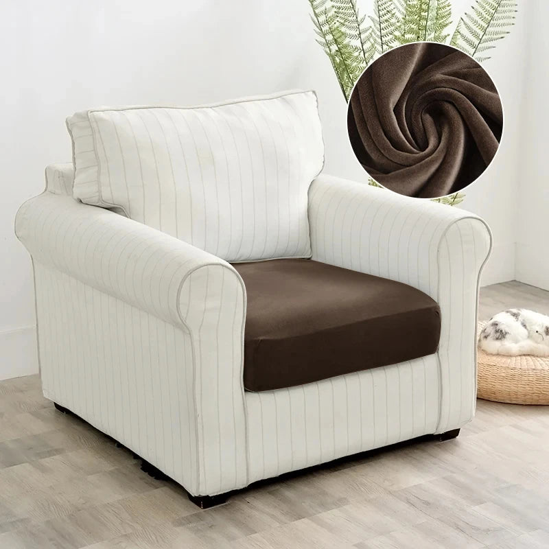 A white upholstered armchair with vertical stripes and a brown seat cover sits on a light wood floor.