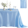 Light blue satin tablecloth set with candles, silverware, and a floral arrangement for elegant dining decor