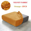 Orange velvet fabric sofa seat covers shown draped over a gray sofa cushion.
