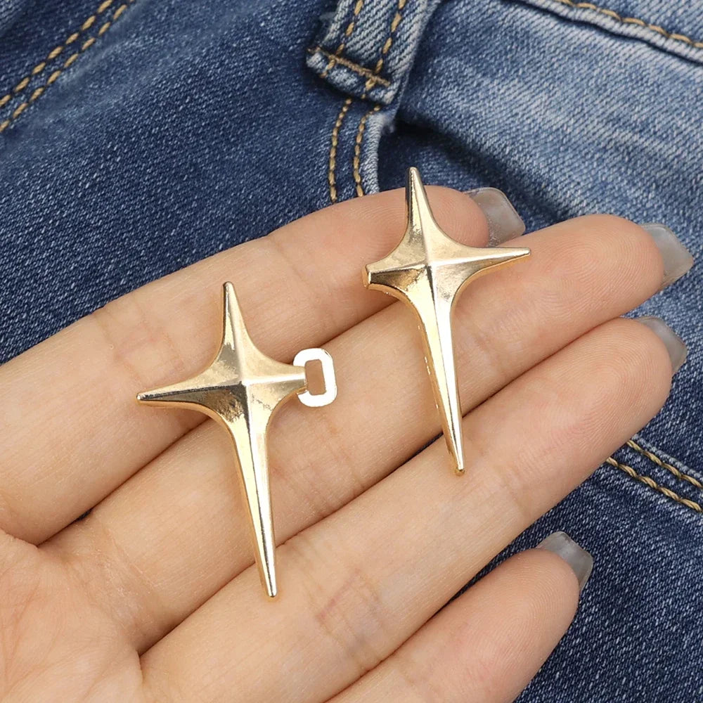 Gold Y2K star clips for jeans and skirts shown on a hand against denim fabric