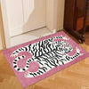 A pink rug featuring a black and white tiger design with tropical palm leaves.