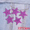 Five glitter pink star patches embroidered on light blue denim fabric