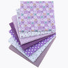A stack of purple and white floral dot pattern cotton fabric squares for DIY crafting.