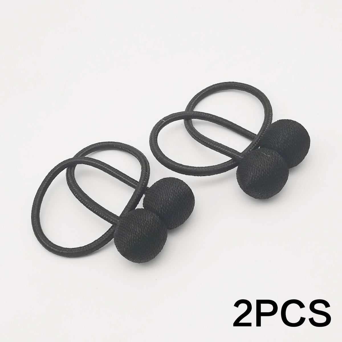 Two black magnetic ball curtain tiebacks with thin black cord.