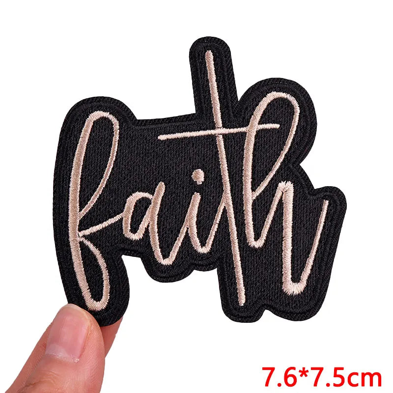 Black embroidered letter iron-on patch spelling out Faith in a flowing script font
