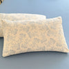 A light beige floral printed pillow cover resting on a blue surface.