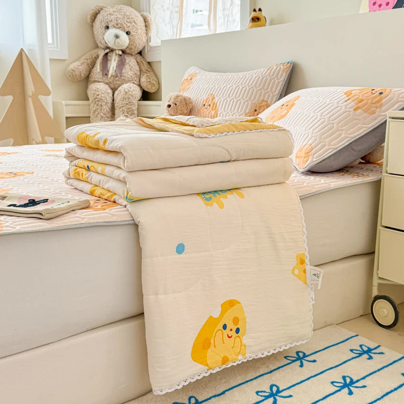 A stack of cream and yellow quilted blankets is displayed on a white surface with stuffed animals in the background.
