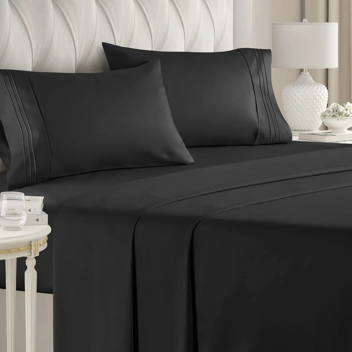 A set of black luxury microfiber bed sheets with deep pockets draped on a bed.