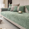 A green linen sofa cover with gray accents and pillows on a light-colored sofa.