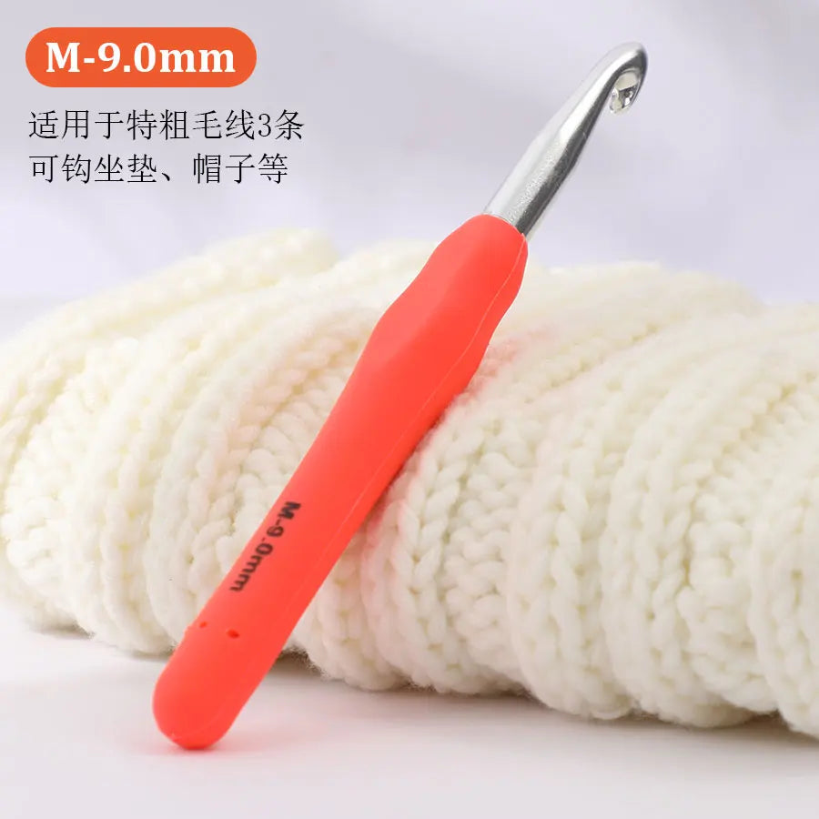 An orange precision aluminum crochet hook with an M-9.0mm size is shown against a background of white yarn.