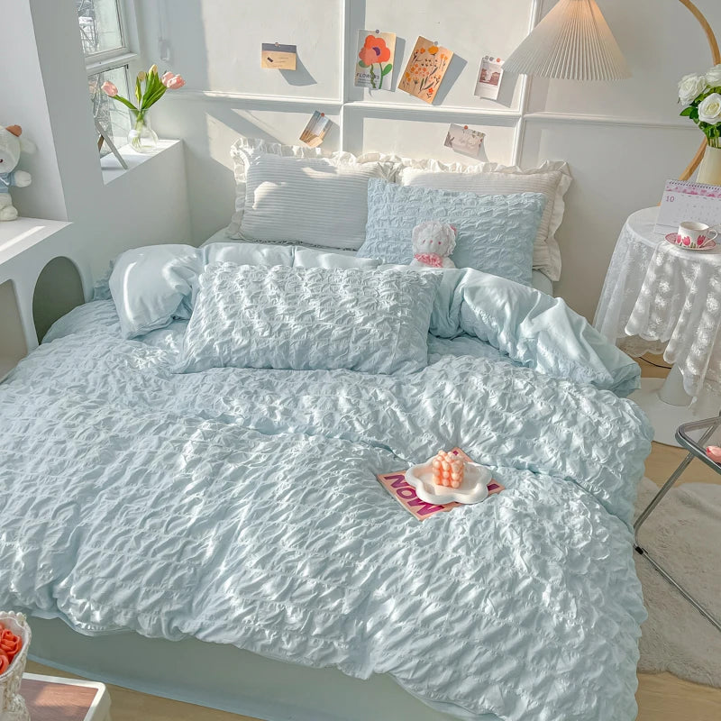 A light blue soft textured duvet cover set with matching pillowcases displayed on a bed.