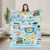 A women models a light blue throw blanket featuring Gilmore Girls themed illustrations and text.