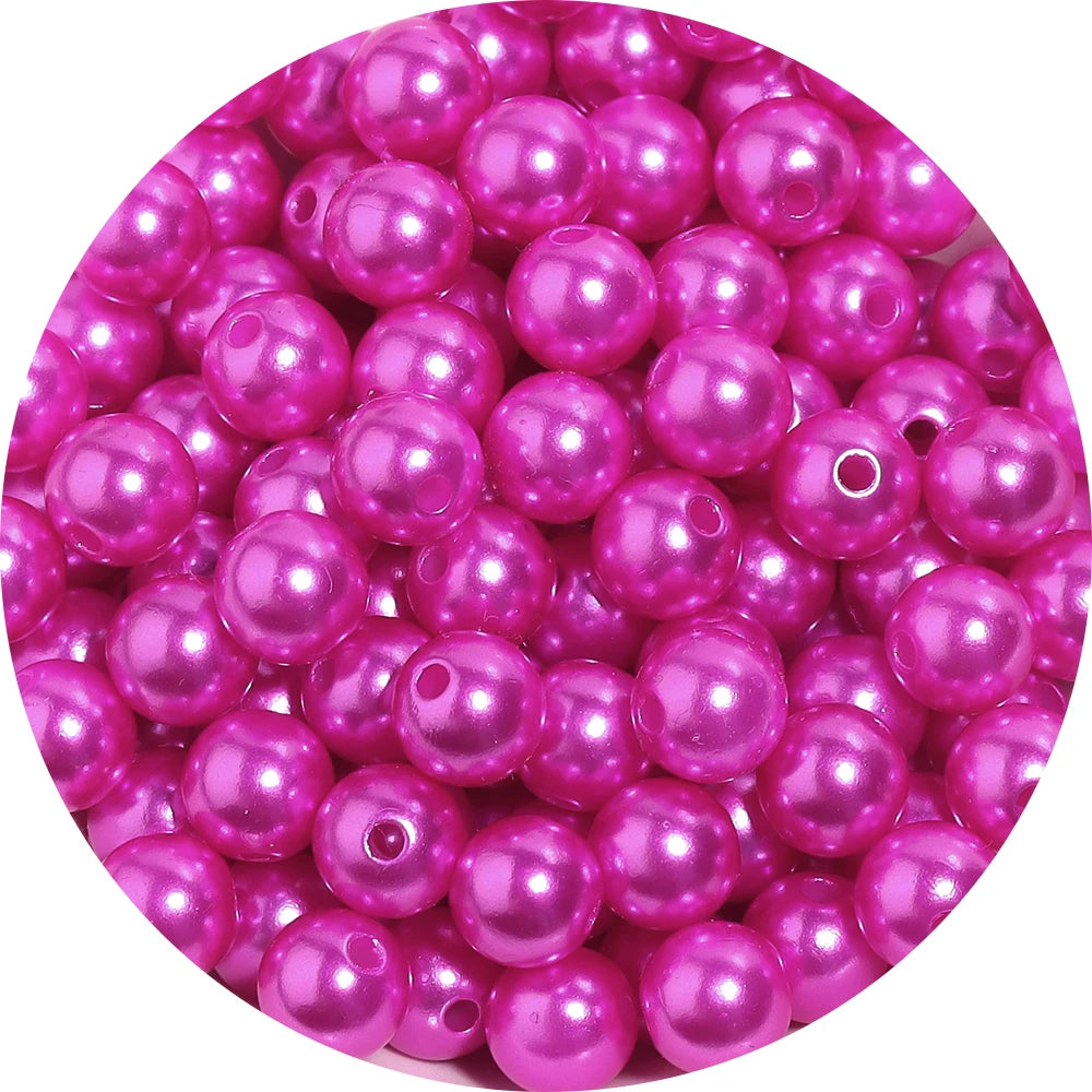 A pile of pink imitation pearl beads used for DIY jewelry making.