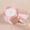 Roll of pink satin craft ribbon with a white center core
