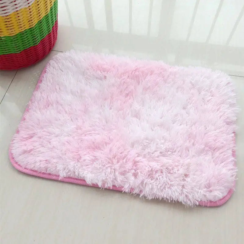 A pink fluffy rug is displayed on a white surface next to colorful woven baskets.