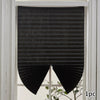 Black non-woven pleated blackout curtains hanging in a white window frame.