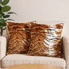 Two brown and white leopard print throw pillows resting on a light-colored sofa.