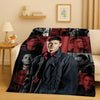 A dark flannel throw blanket featuring a collage of male portraits in various tones and lighting.