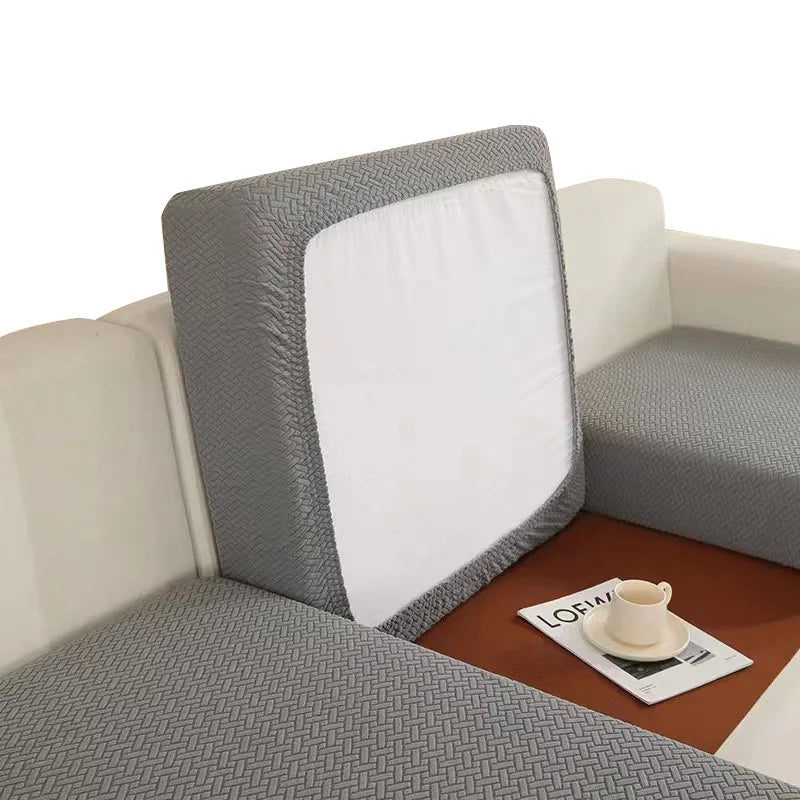 A gray sofa seat protector cushion cover with a white insert resting on a brown tray.