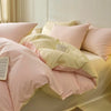 A set of pink and cream polyester bedding including duvet covers and pillowcases on a bed.