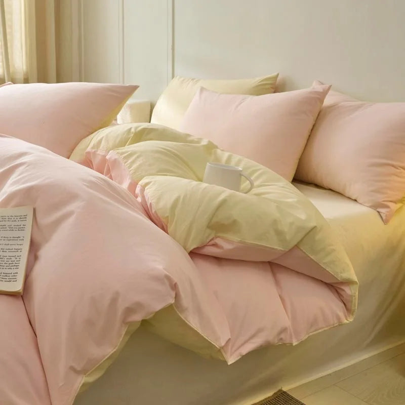 A set of pink and cream polyester bedding including duvet covers and pillowcases on a bed.