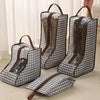 A portable boot storage bag with a carry handle shown in various shades of gray and black fabric.