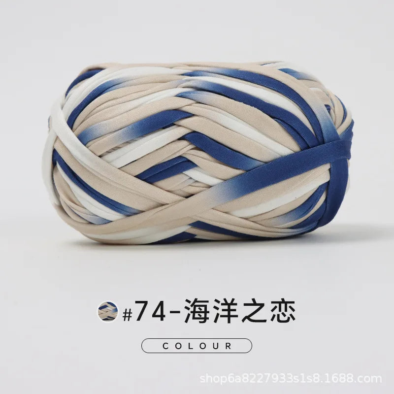 A ball of hand-dyed fabric strip yarn featuring blue and beige stripes for crochet and knitting.