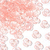 Pink resin flower bead caps scattered on a white background for jewelry making
